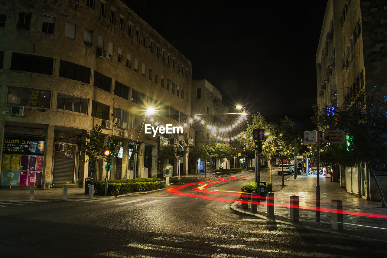 ILLUMINATED LIGHT TRAILS ON ROAD AT NIGHT