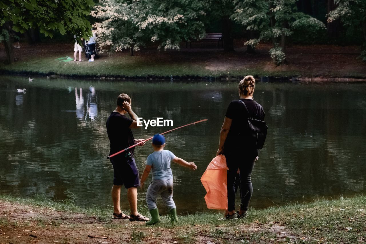 PEOPLE STANDING BY LAKE