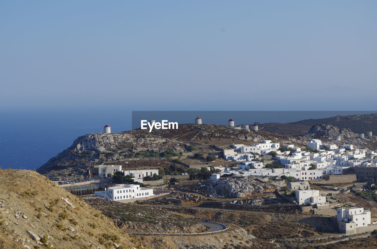 Town by sea against clear blue sky