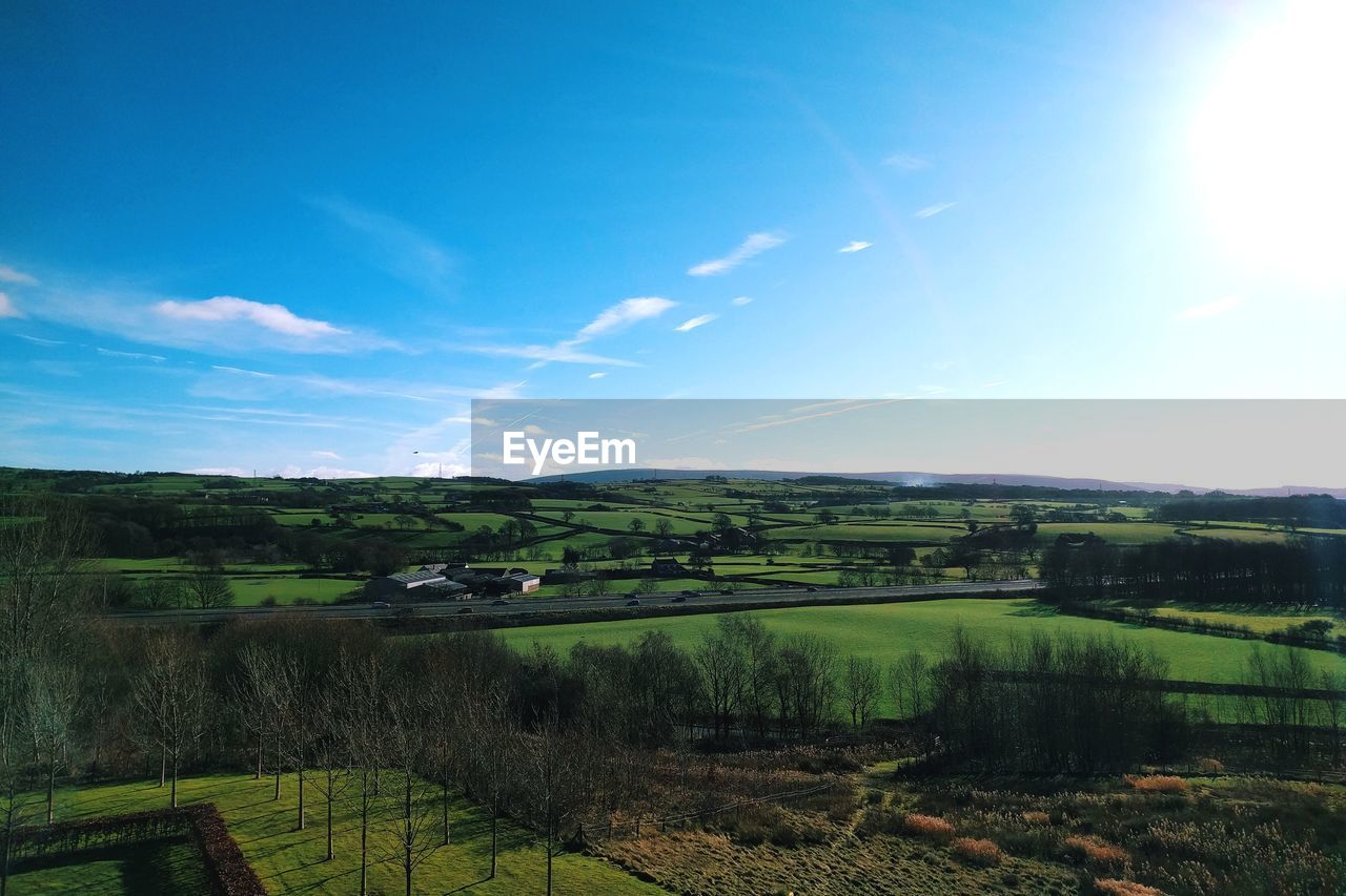 SCENIC VIEW OF FARM AGAINST BLUE SKY