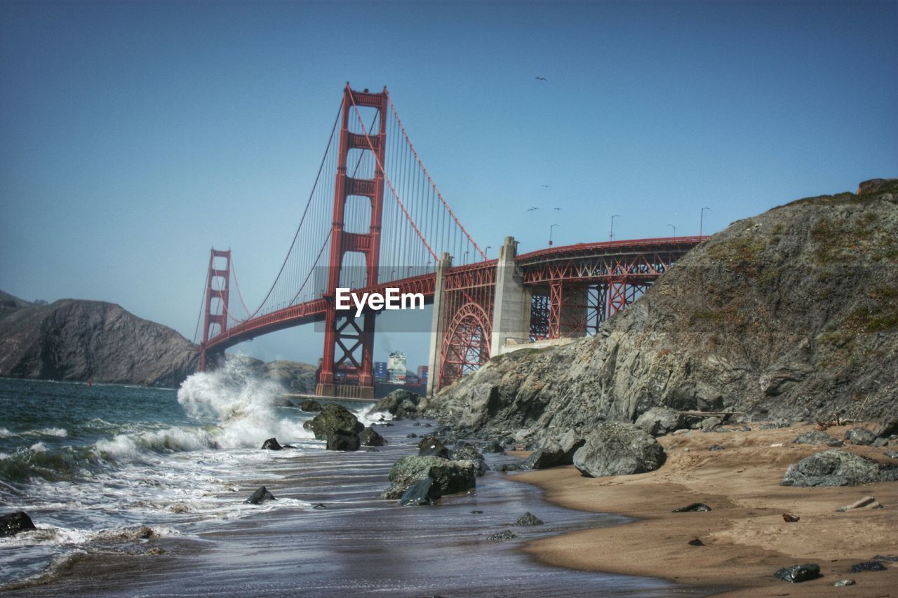 Low angle view of golden gate bridge over bay against sky