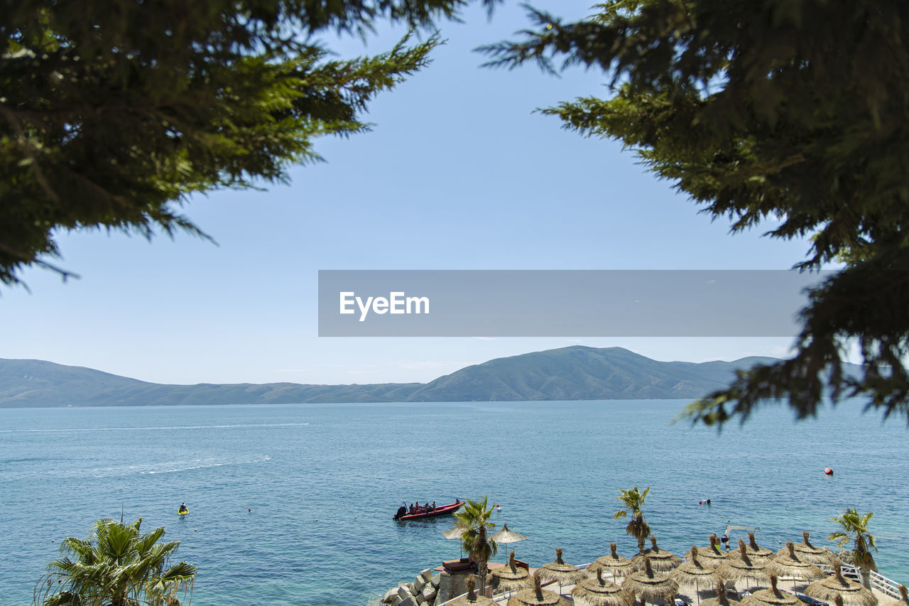 SCENIC VIEW OF SEA BY MOUNTAIN AGAINST SKY