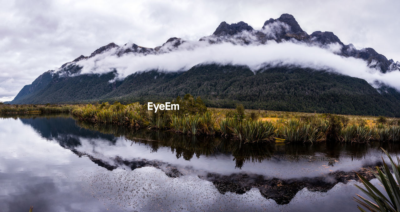 Scenic view of lake by mountains against sky