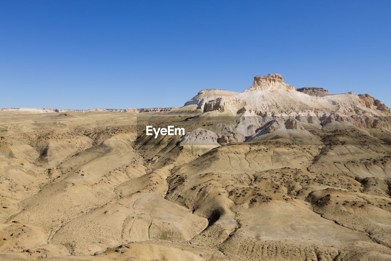 rock formations on desert against clear blue sky