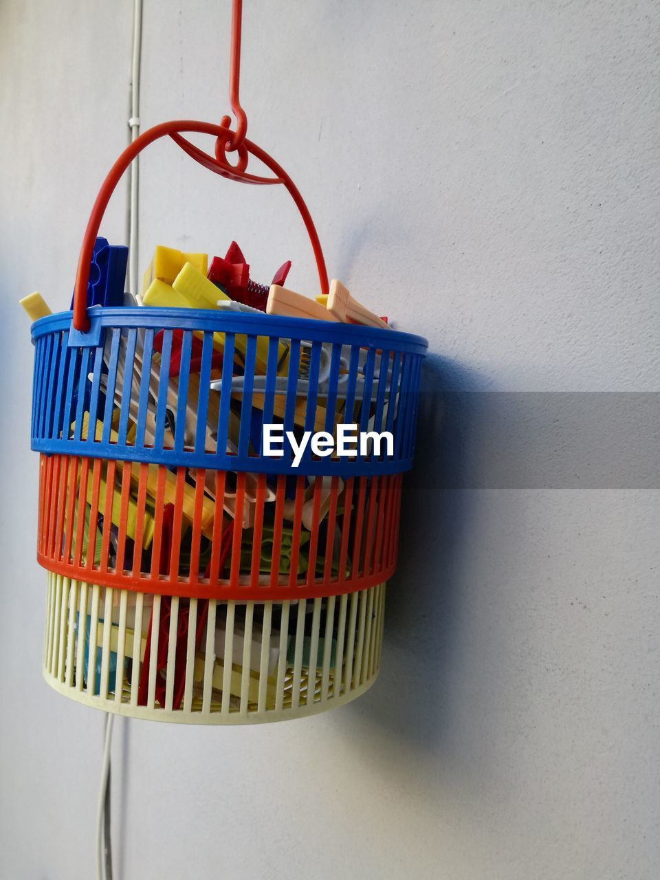 Close-up of toys in basket hanging on wall