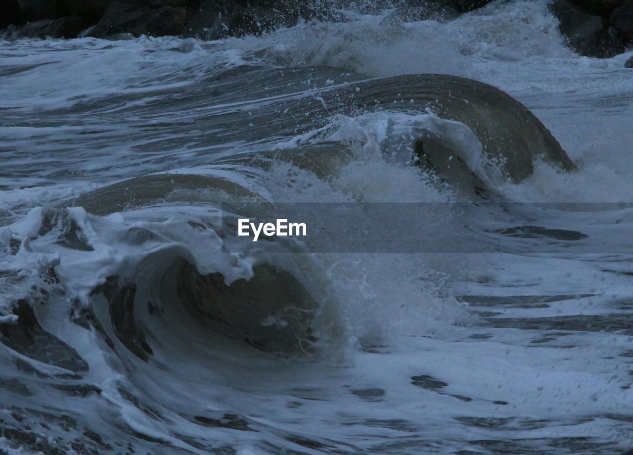 High angle view of sea waves splashing at beach