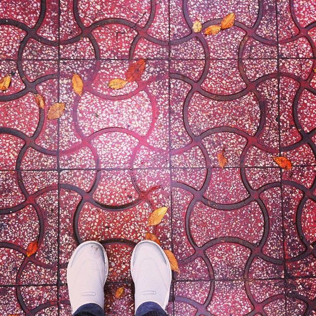 LOW SECTION OF PERSON STANDING ON TILED FLOOR