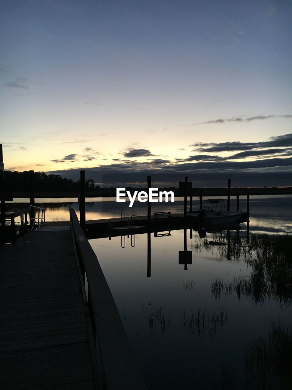 PIER OVER LAKE AGAINST SKY AT SUNSET