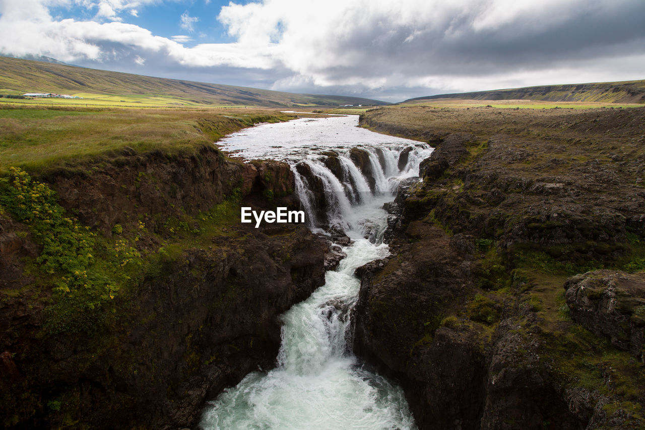 Scenic view of waterfall against sky