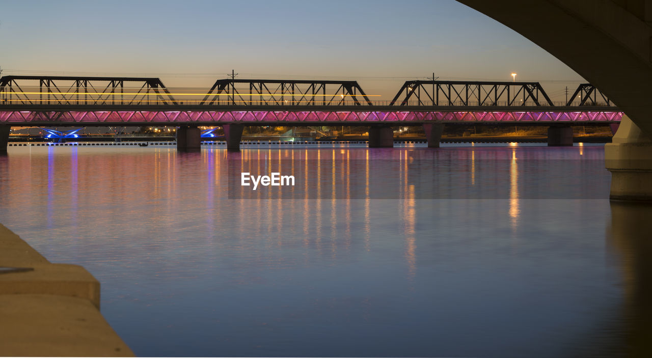 Bridge over river against sky during sunset