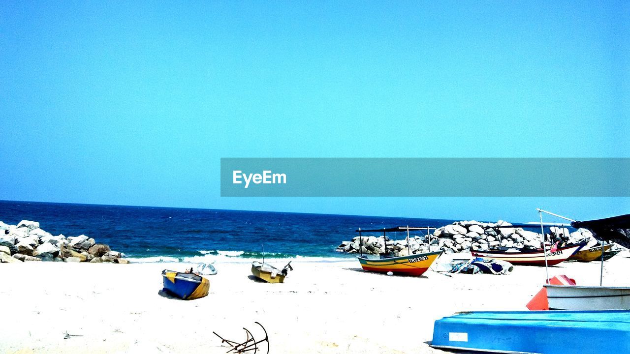 Boats on beach against clear sky