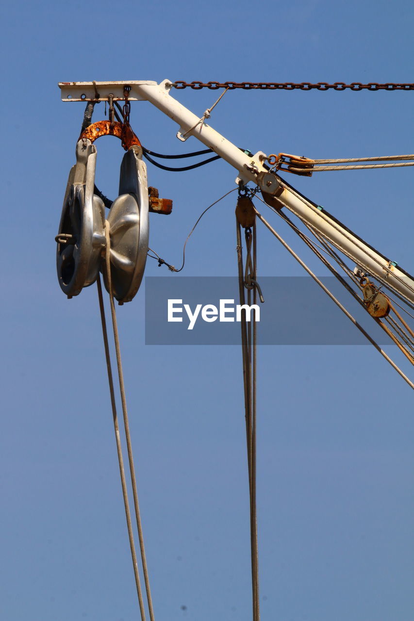 Fishing boat pulley against the blue sky