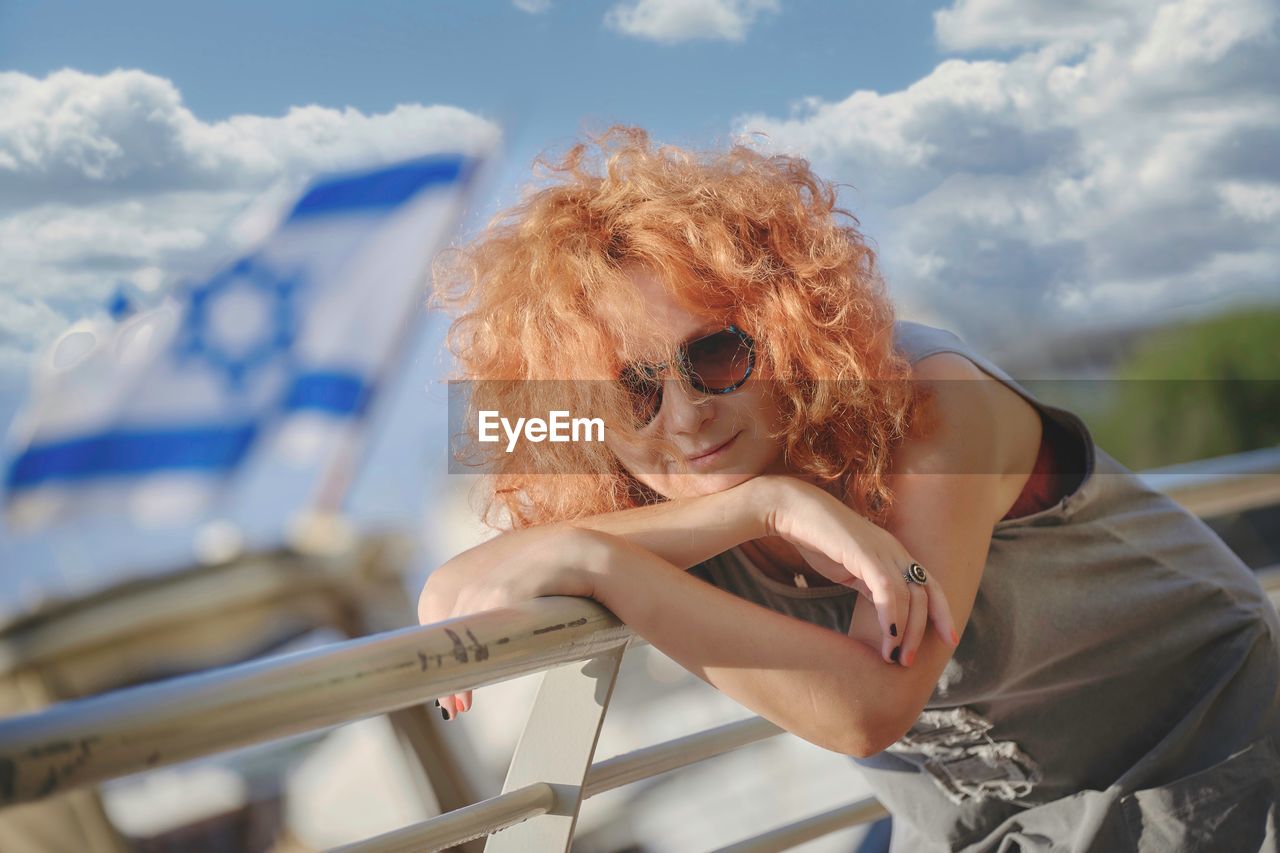 PORTRAIT OF WOMAN WEARING SUNGLASSES OUTDOORS