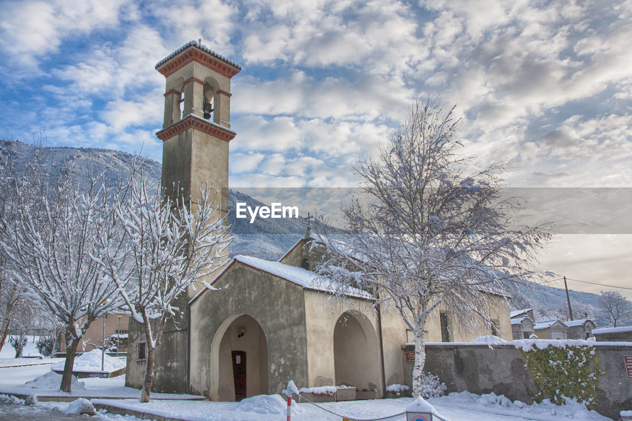 Low angle view of church against cloudy sky during winter