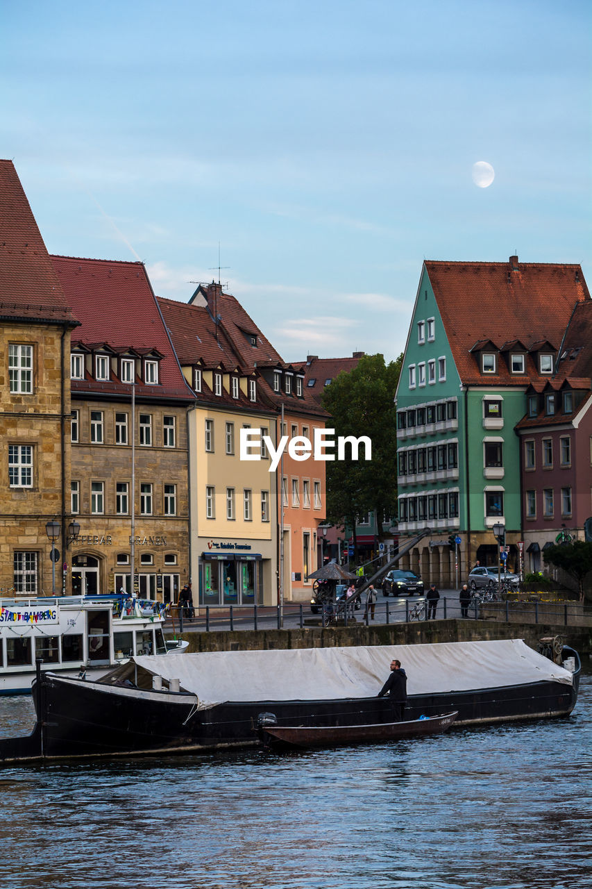 Boat on river against sky at bamberg