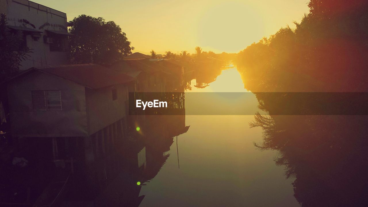 Stilt houses on river during sunset