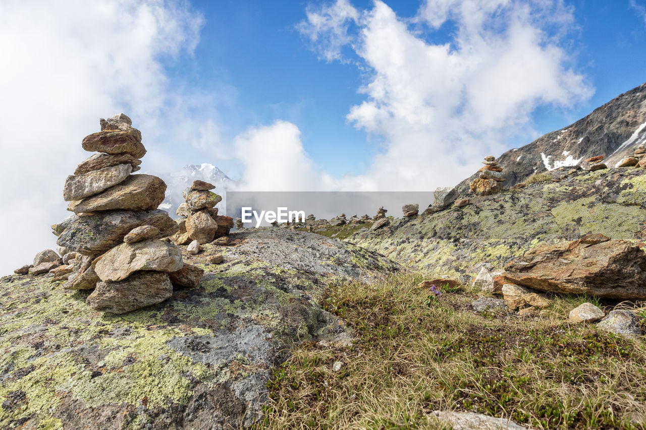 Stacked rocks on mountain against sky