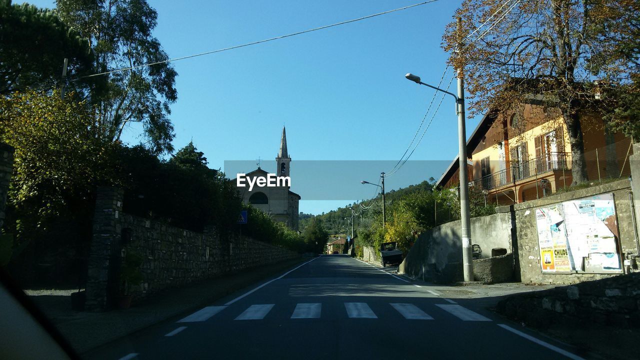 Street amidst buildings against clear sky