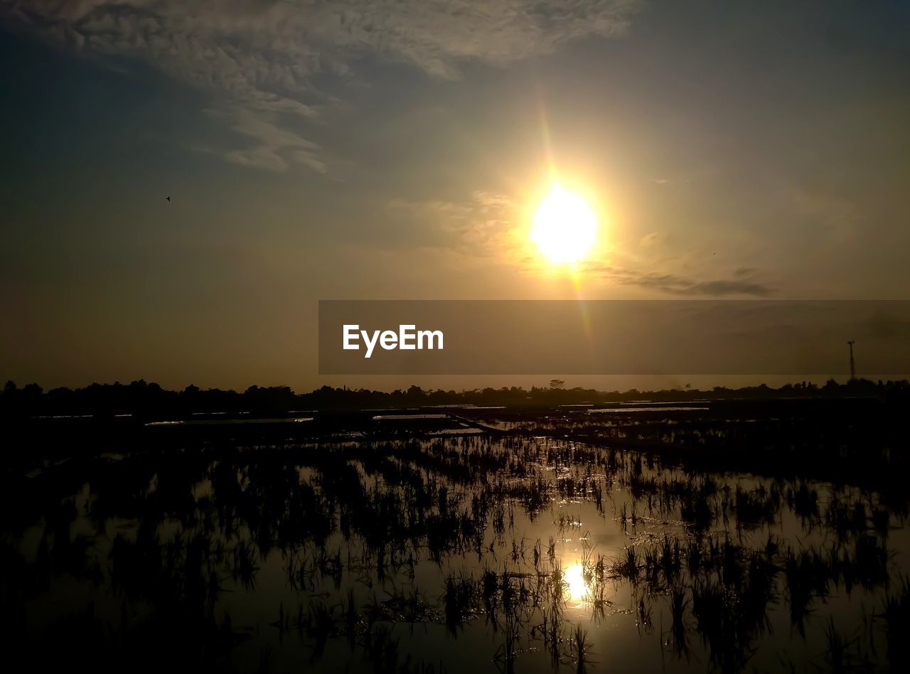 Scenic view of lake against sky during sunset