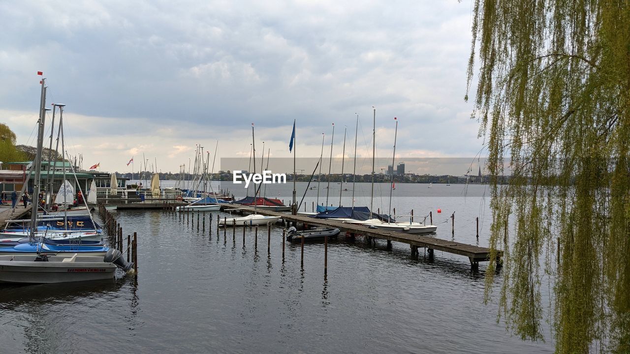 SAILBOATS MOORED IN HARBOR