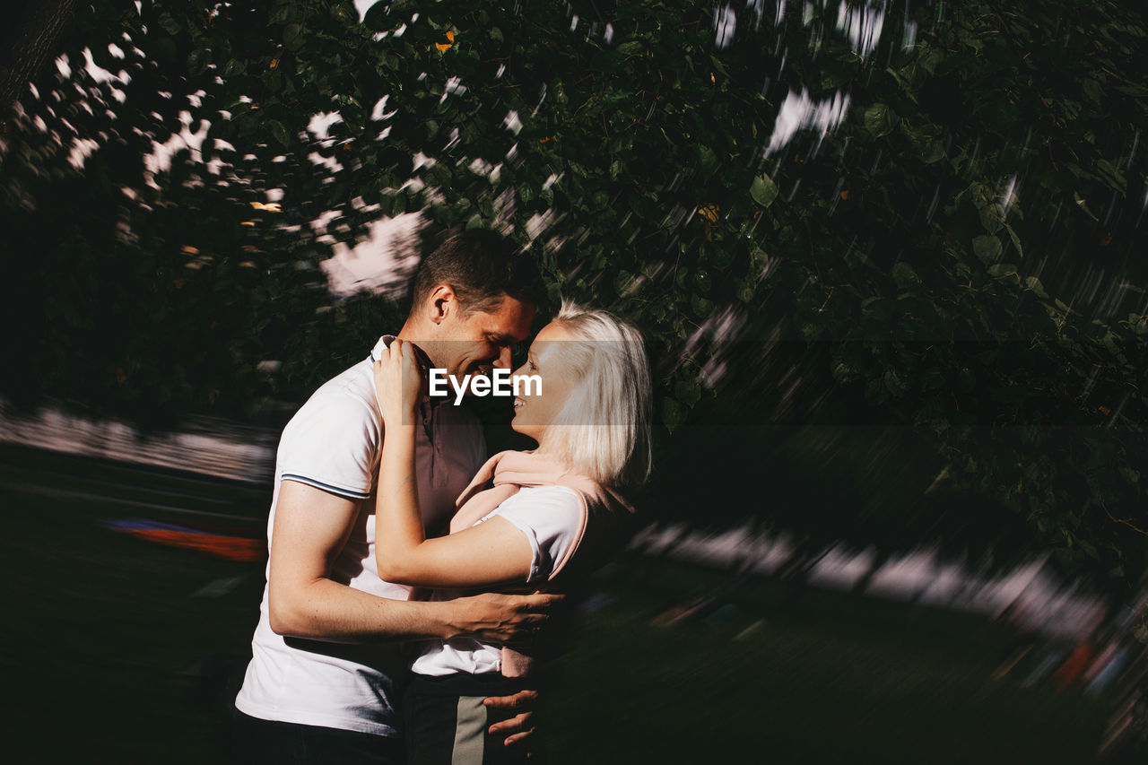 Couple embracing against tree