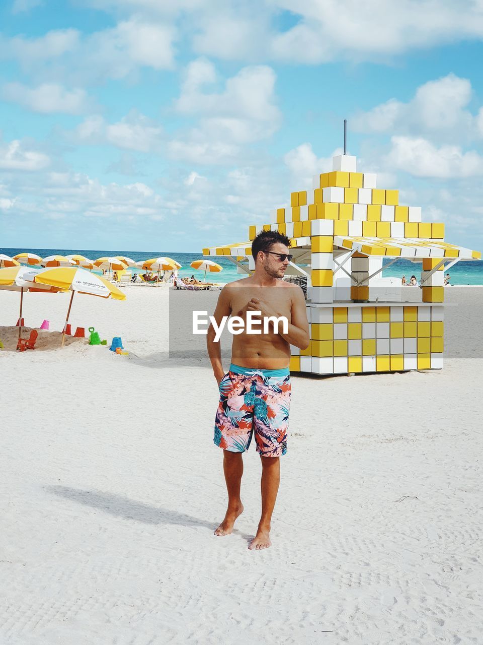 FULL LENGTH OF SHIRTLESS MAN ON BEACH