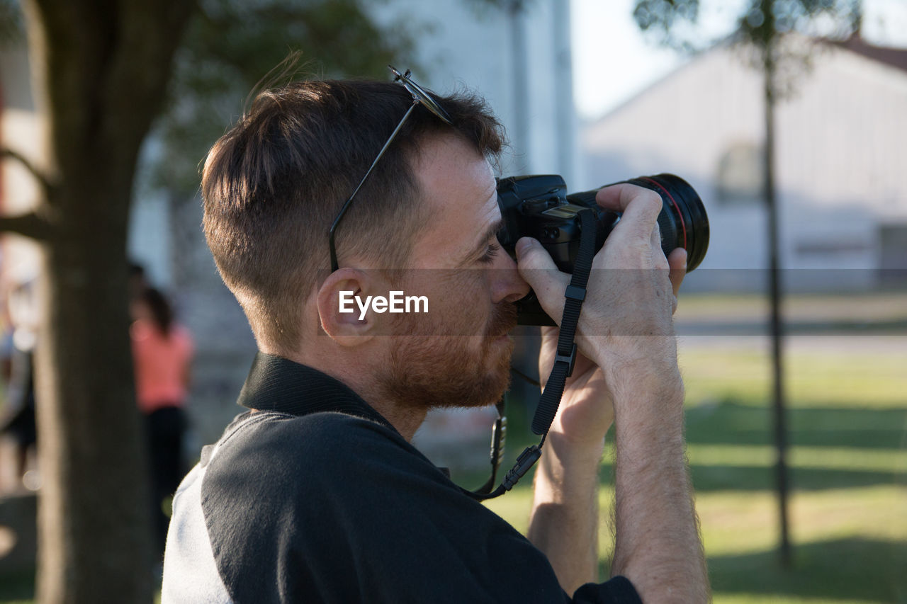 Portrait of man photographing outdoors