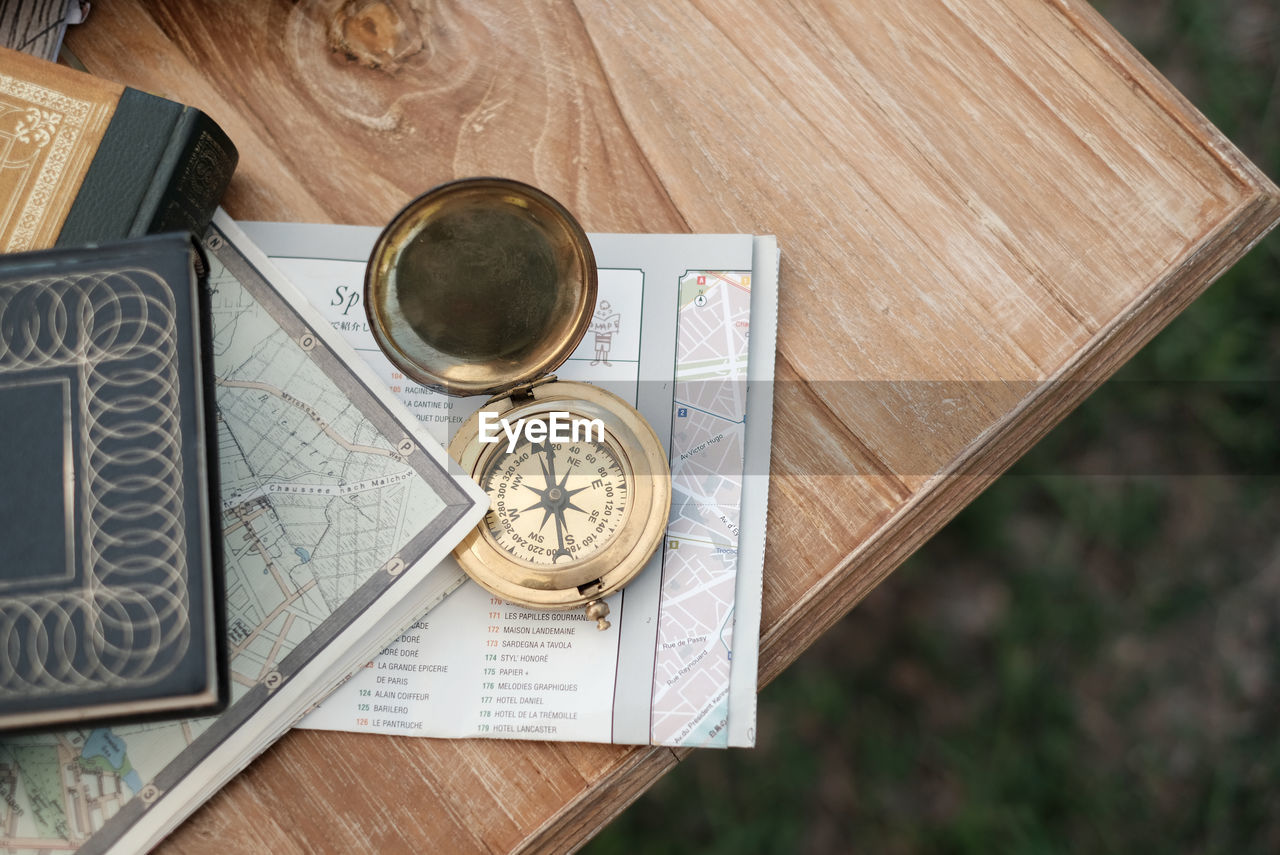 High angle view of navigational compass on paper