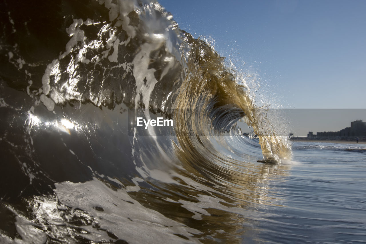 Water splashing in sea against clear sky