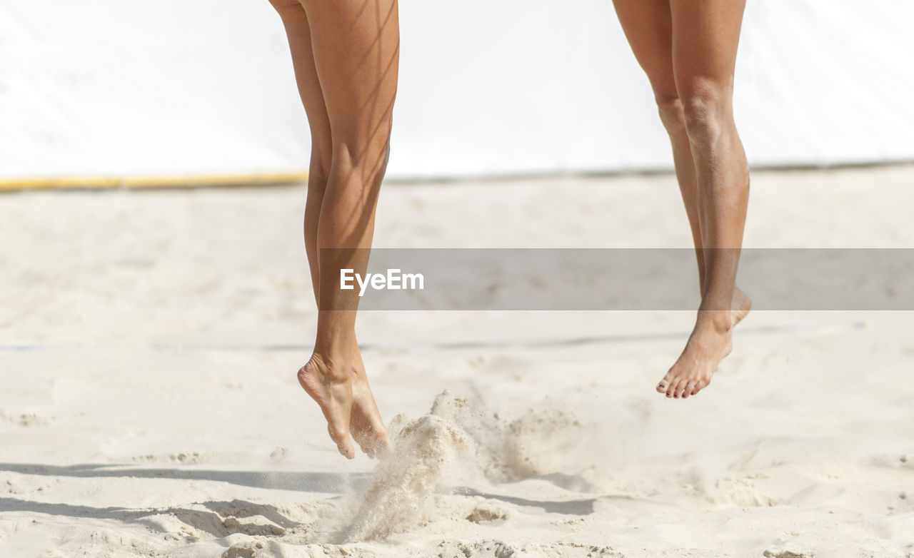 Low section of women playing beach volleyball