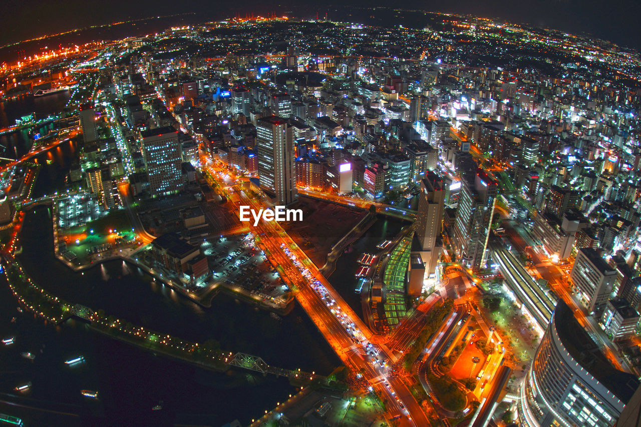 HIGH ANGLE VIEW OF ILLUMINATED CITY BUILDINGS AT NIGHT