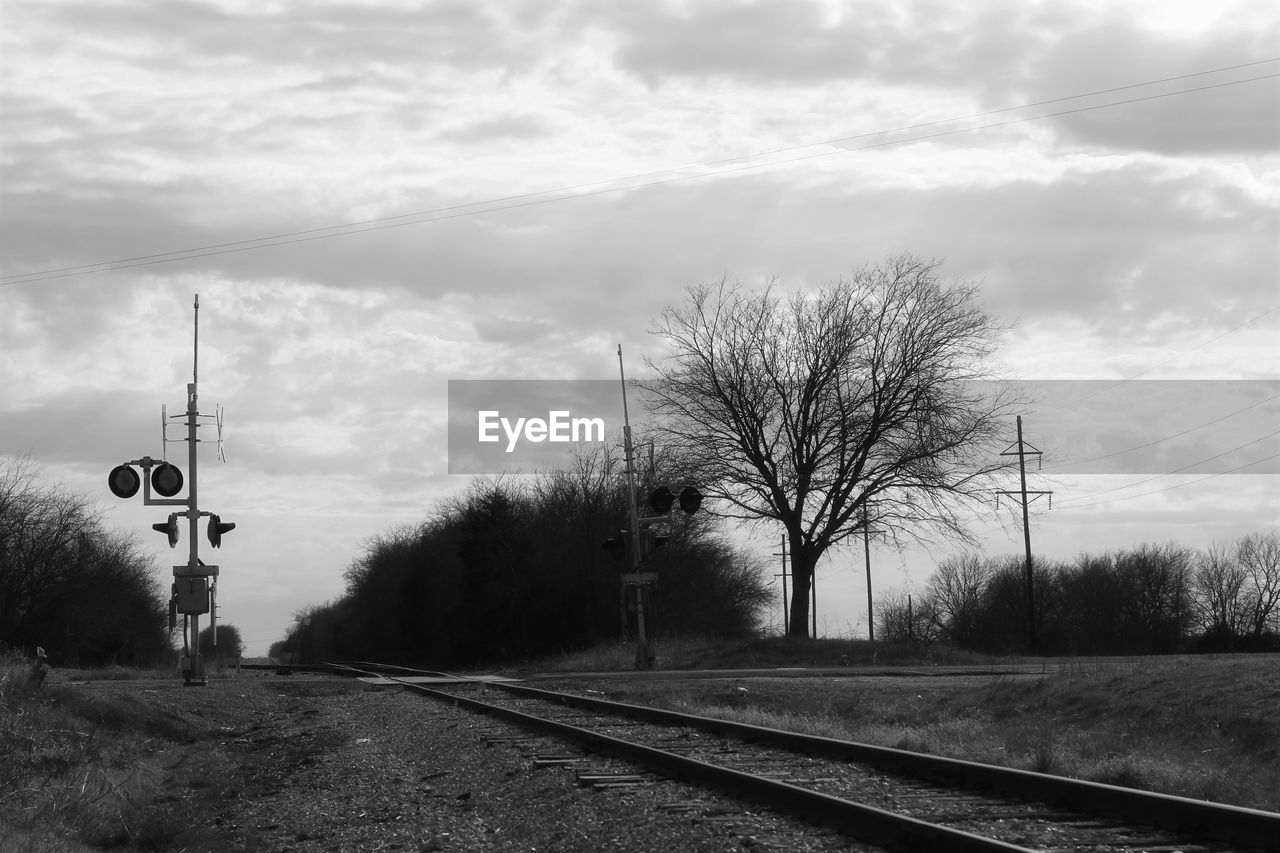 Railroad tracks by trees against sky