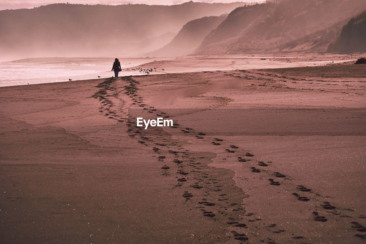 Full length of woman on beach against sky