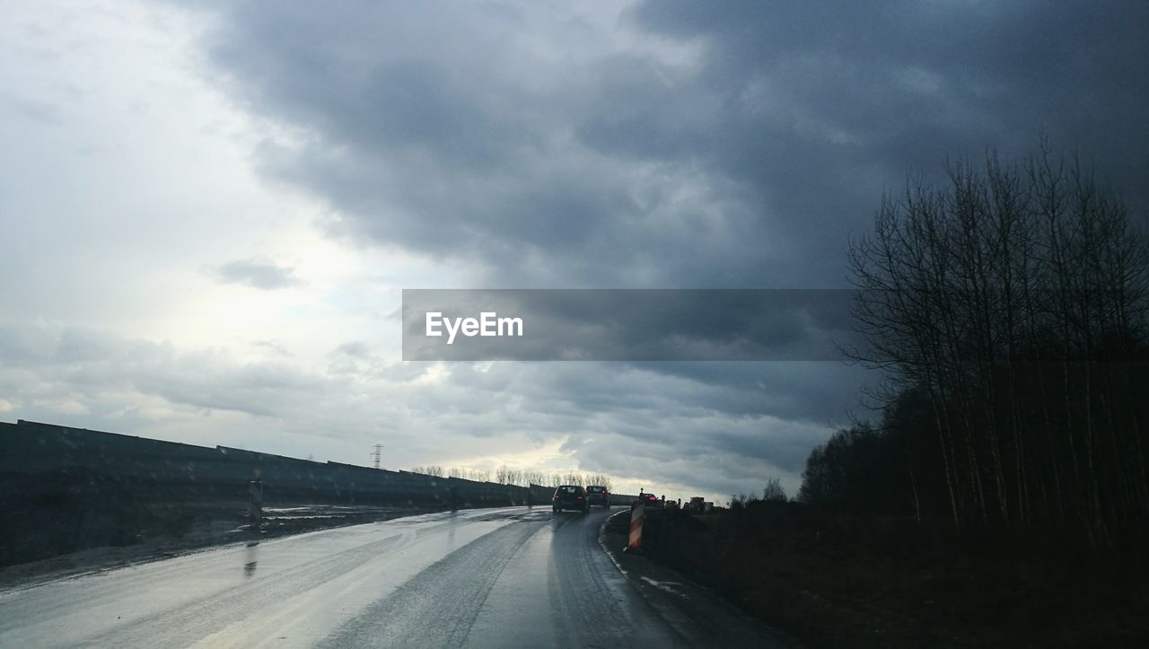 ROAD AGAINST CLOUDY SKY