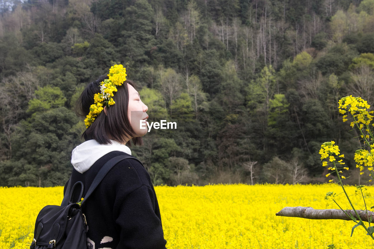 Woman with yellow flower crown in field