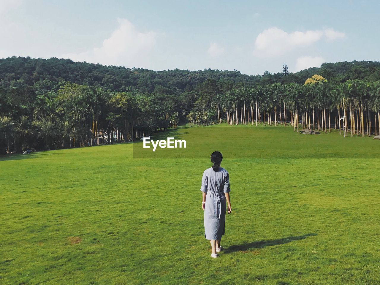 Rear view of woman walking on field