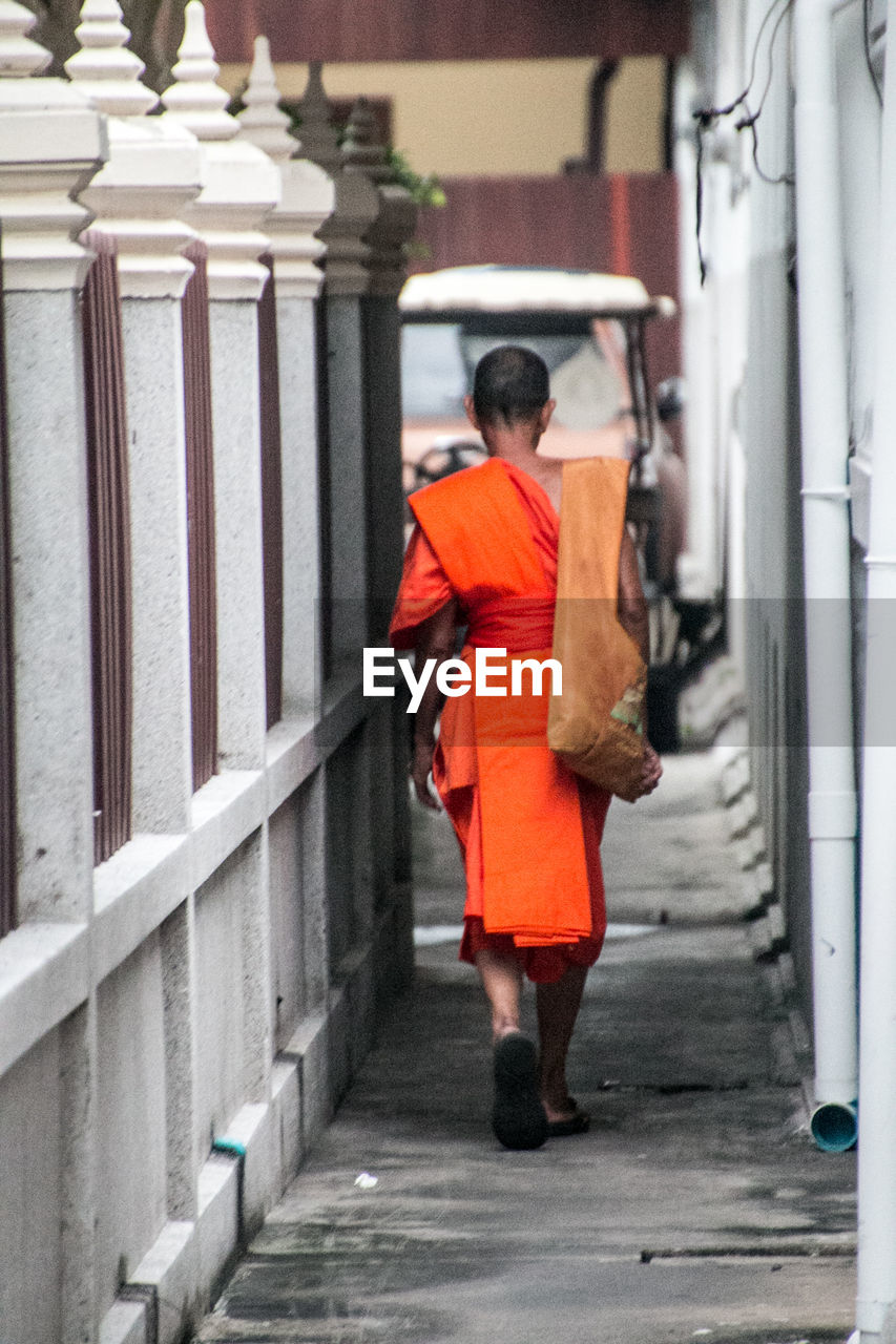 FULL LENGTH REAR VIEW OF MAN WALKING IN CORRIDOR