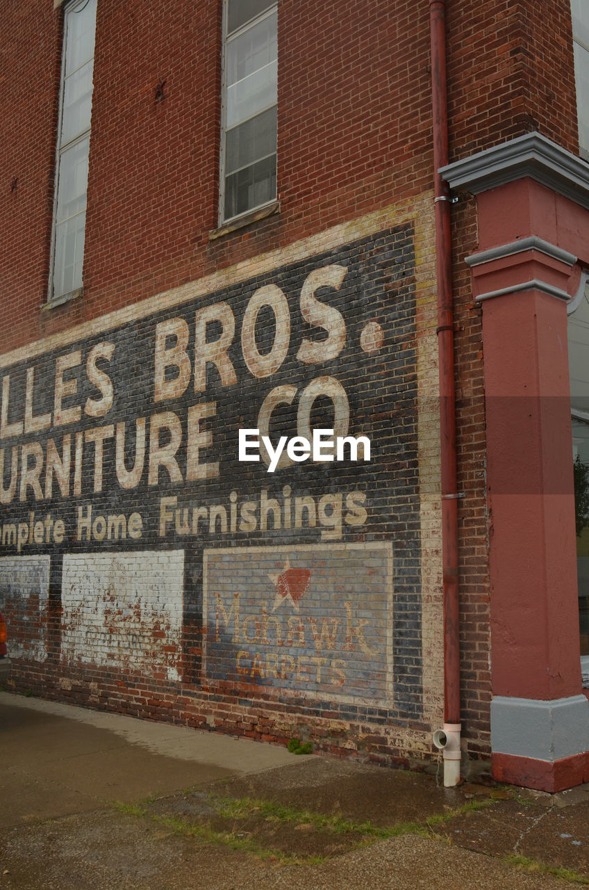 TEXT ON BRICK WALL WITH BUILDING