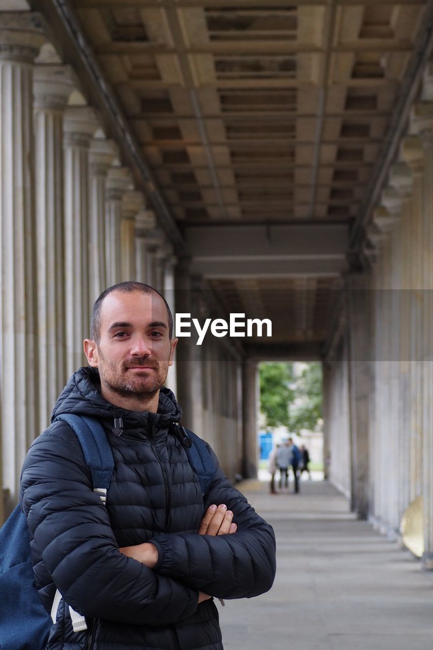 PORTRAIT OF MAN STANDING AT BUILDING