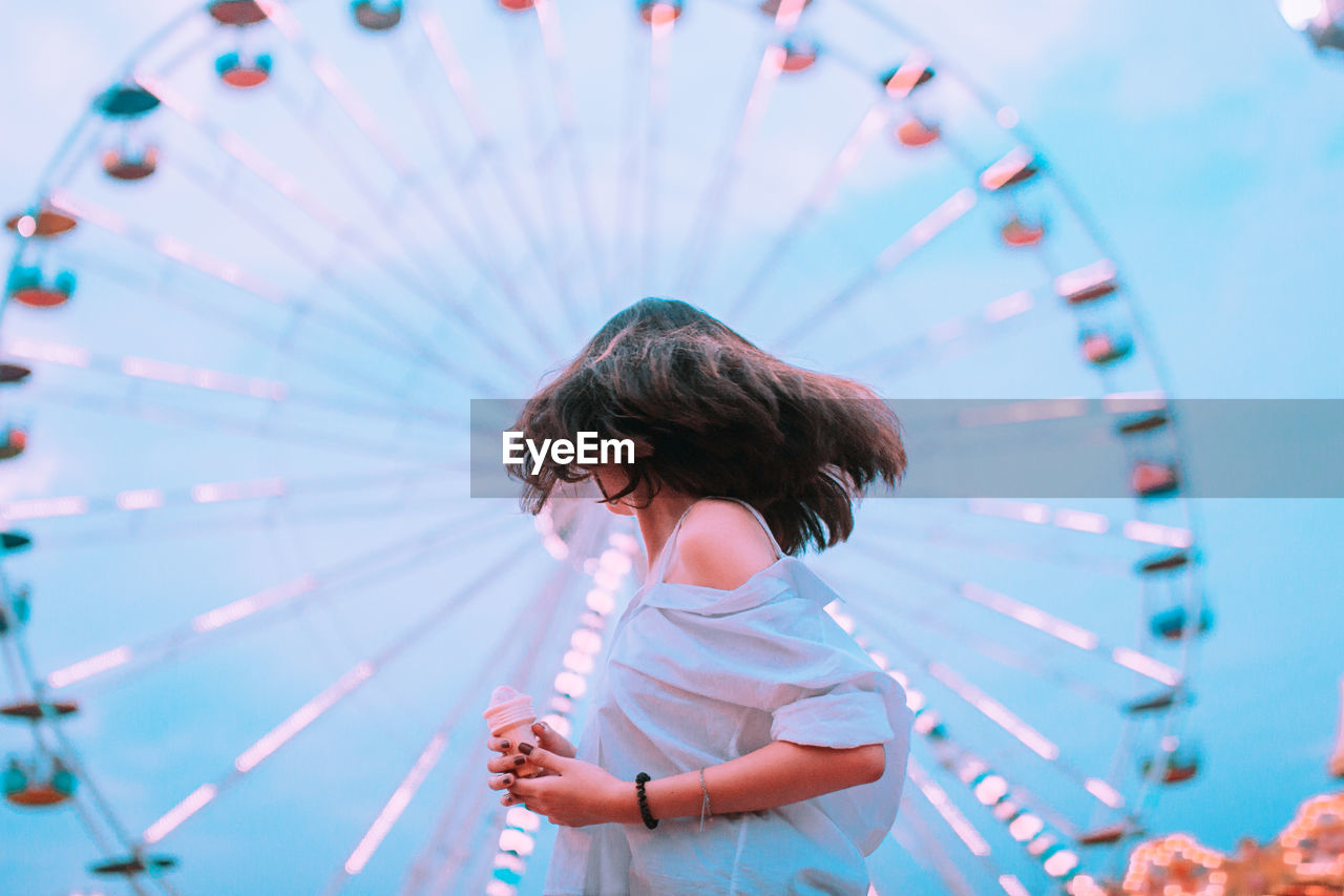 Young woman tossing hair at amusement park