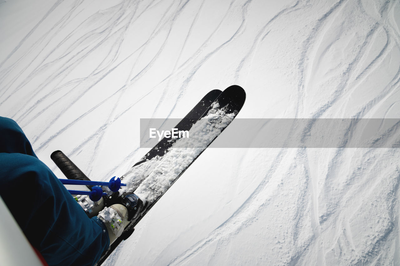 A skier sits on a chair lift on a beautiful day, alpine mountains. skiing concept. side view of a