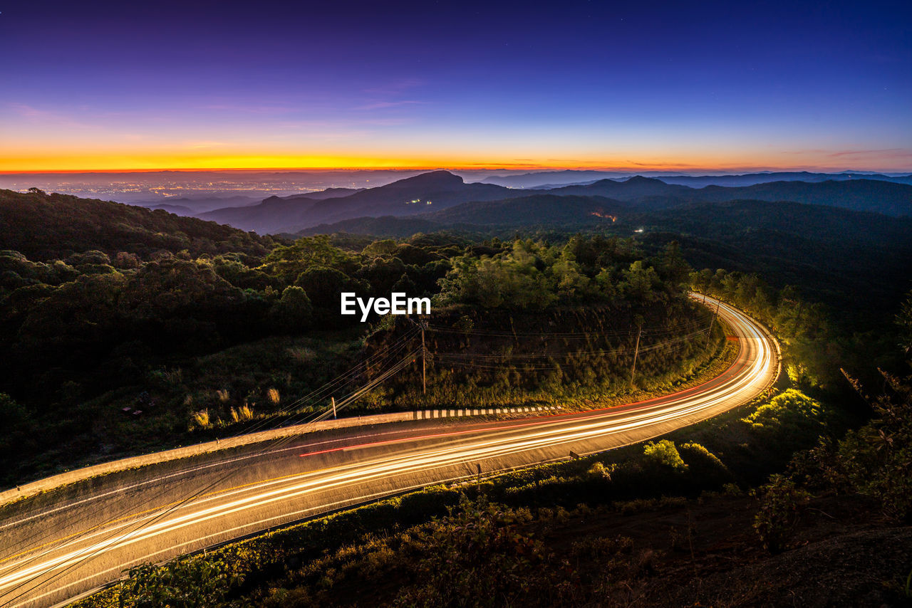 High angle view of light trails on road against sky at night