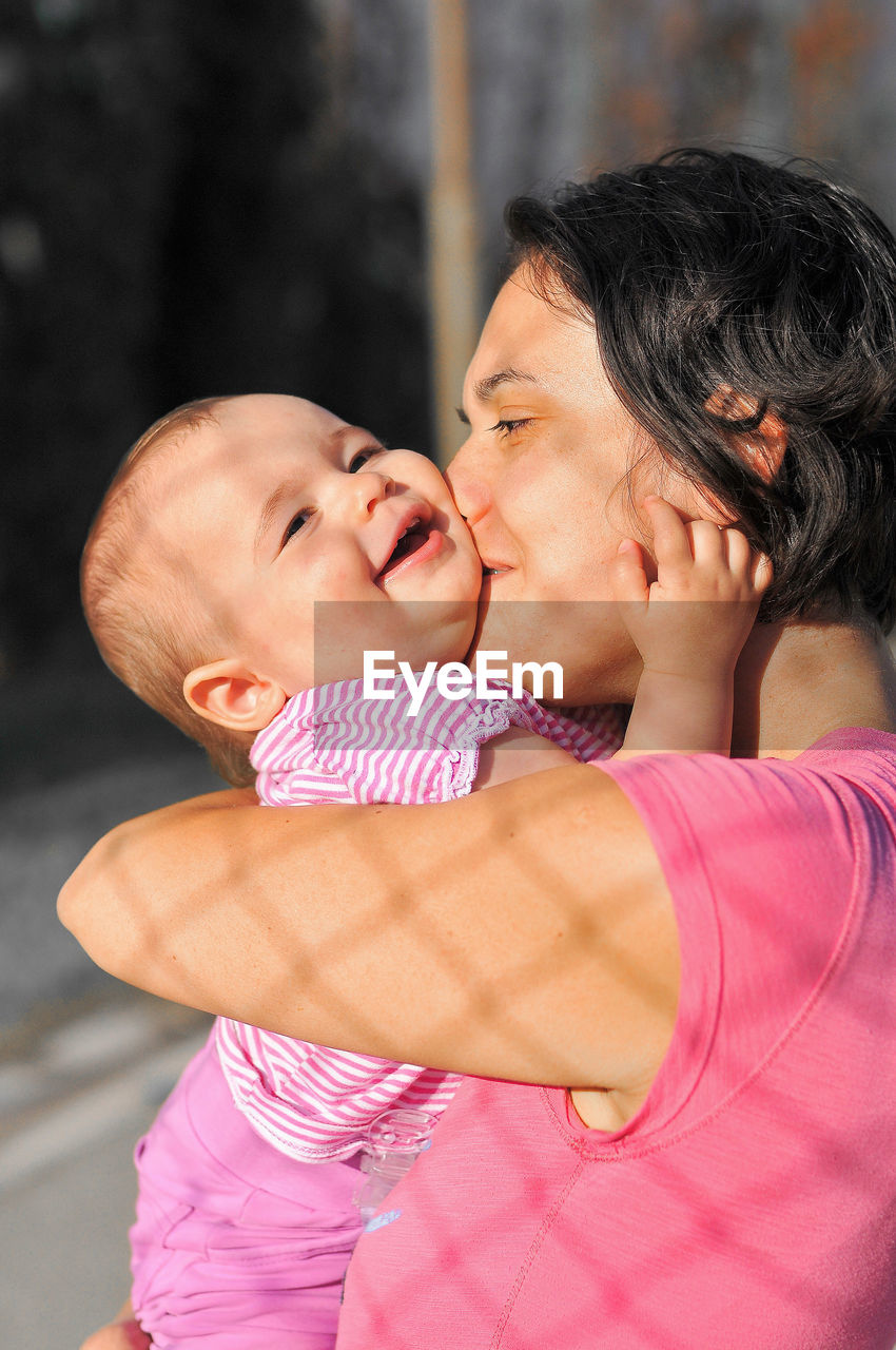 Close-up of mother embracing cute baby