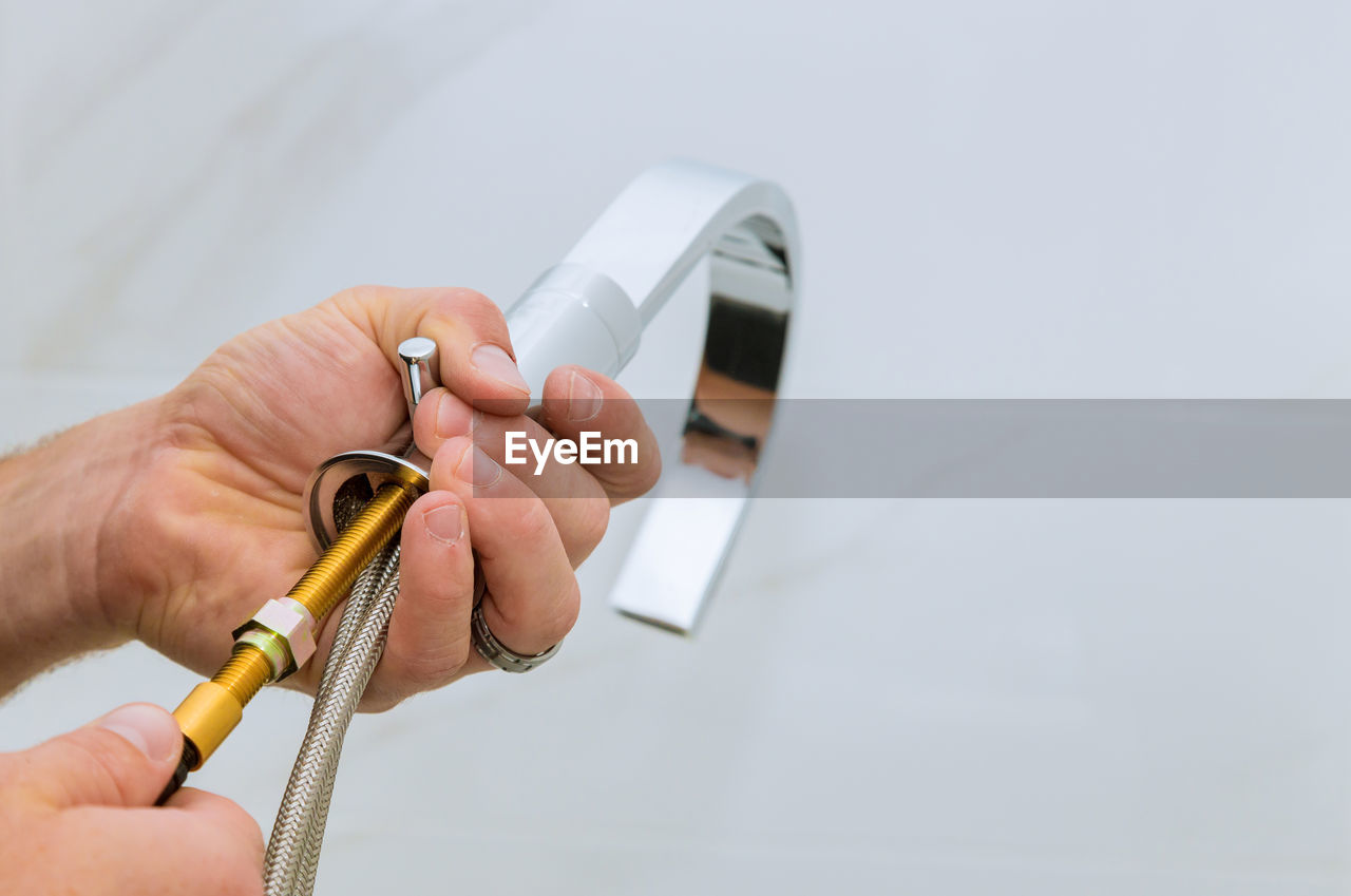 Cropped hands of plumber working in bathroom