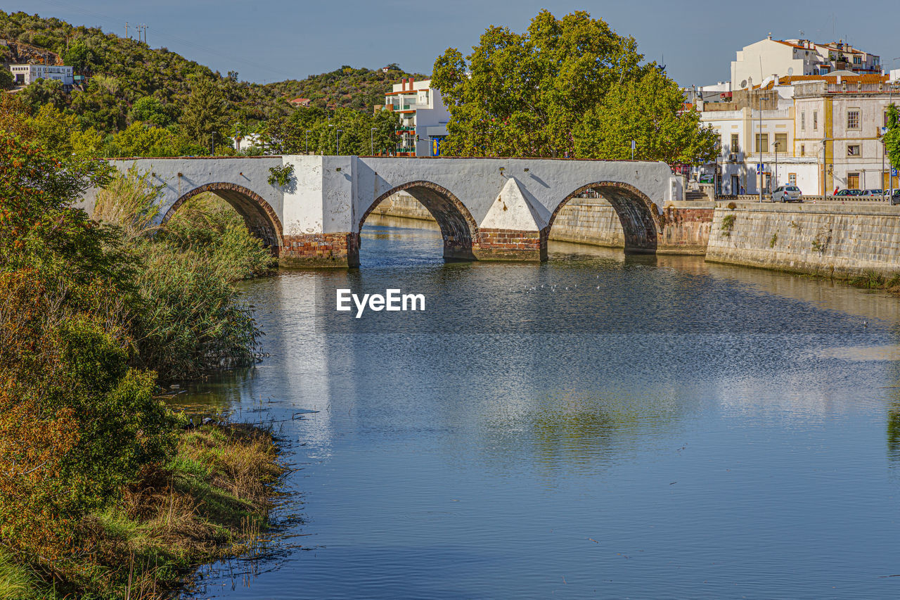 architecture, water, built structure, bridge, river, reflection, arch, arch bridge, nature, building exterior, travel destinations, plant, tree, history, waterway, city, sky, travel, the past, transportation, no people, building, tourism, outdoors, day, moat, waterfront, clear sky, landscape, reservoir, environment, blue