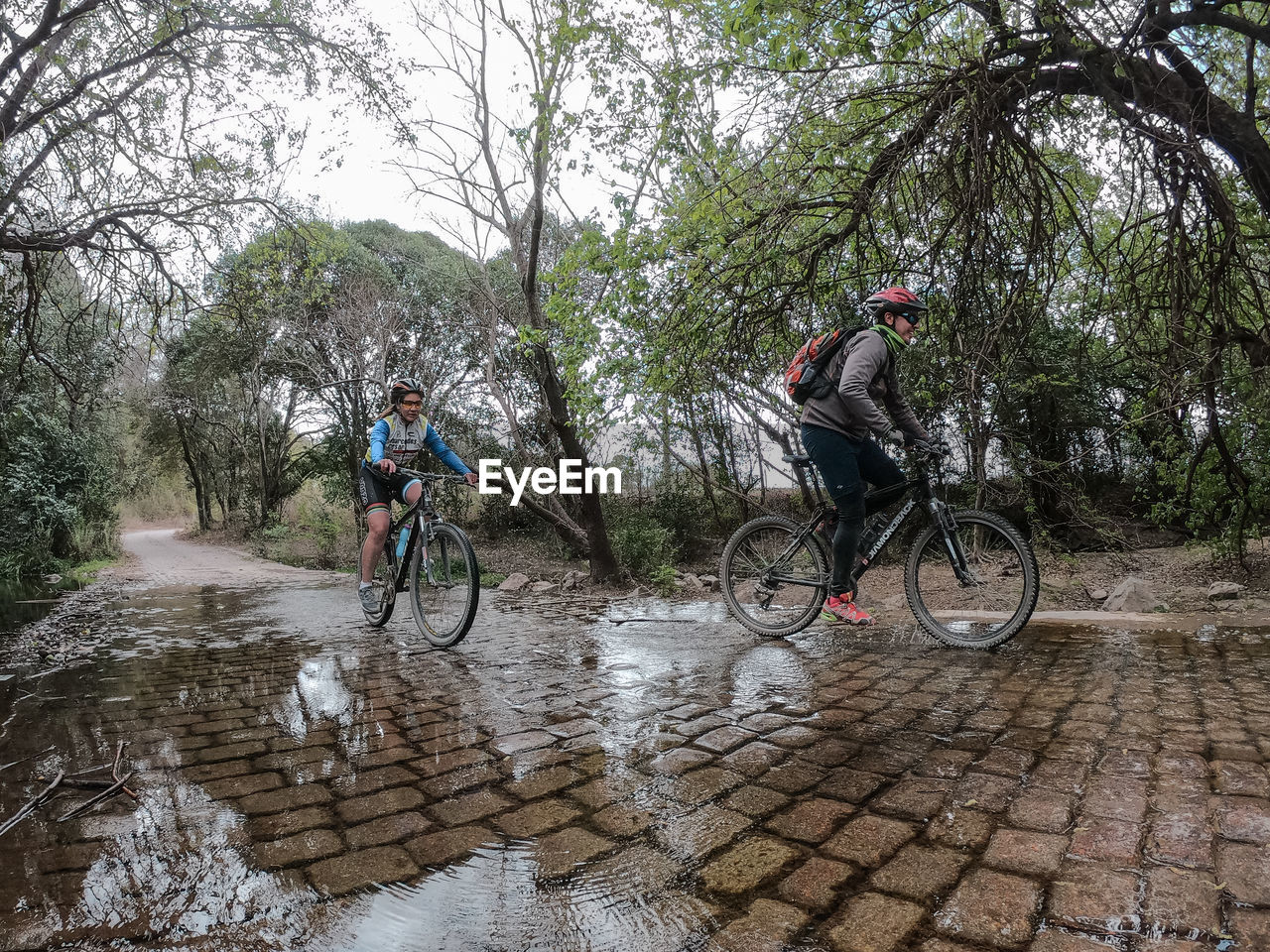 PEOPLE RIDING BICYCLE IN RAIN