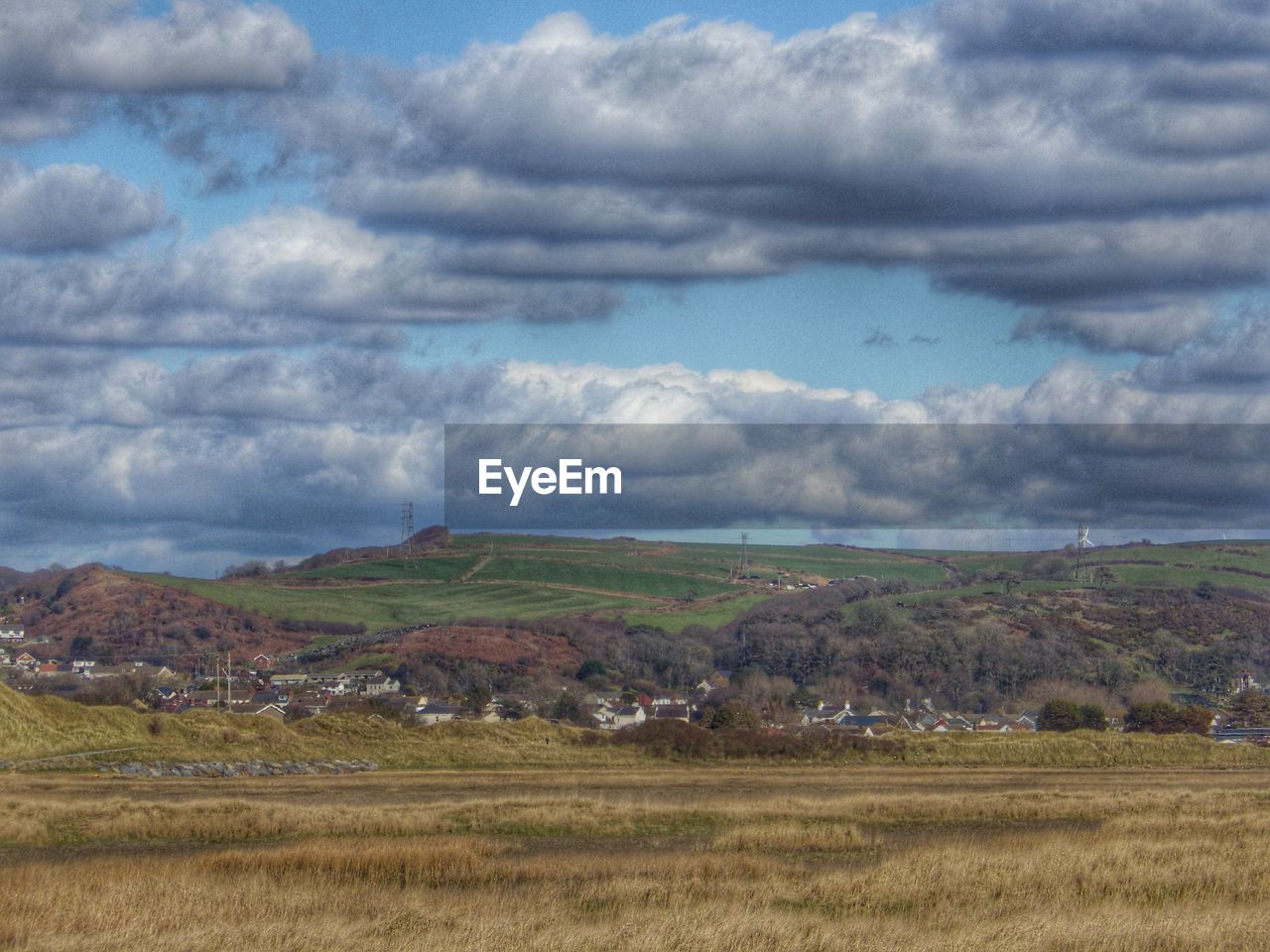 Scenic view of grassy field against cloudy sky