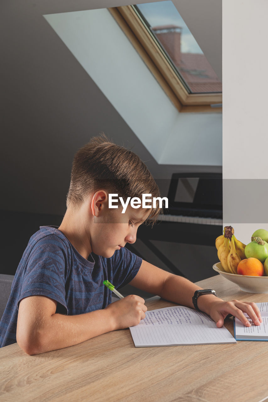 Full length of boy on table at home