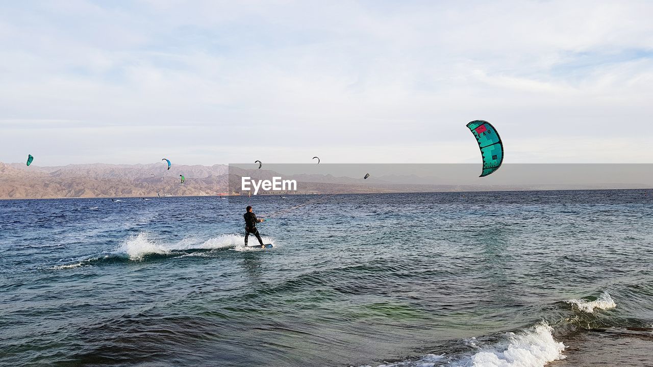 Man windsurfing in sea against sky