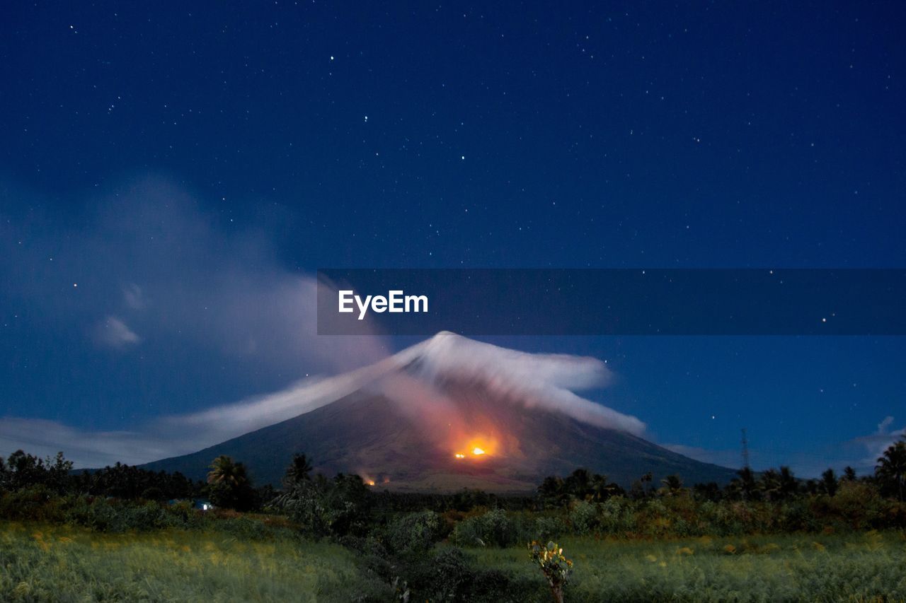 Scenic view of mayon volcano with bush fire at night